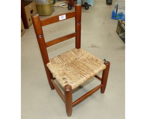 A doll's/child's rush seat ladder back chair