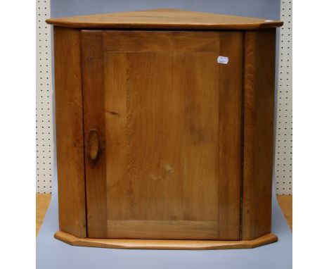 An Ercol type light elm corner cupboard.