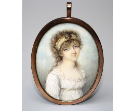 An early 19th century three quarter, oval portrait miniature on ivory of a young lady  dressed in a white Empire dress. Mount