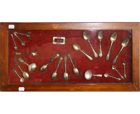 A cased wall display of mostly 19th silver spoons and other items including caddy spoons , enamel buckle and other items. Mix
