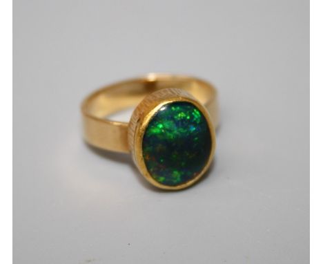 A yellow gold opal ring rub over set oval cabochon black opal&nbsp;