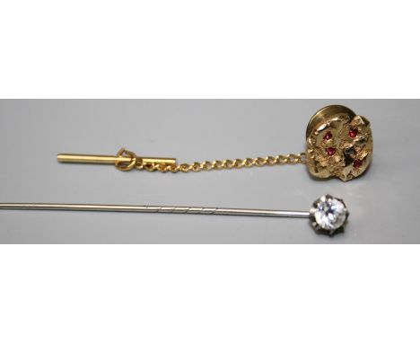 A tie pin fashioned as a gold nugget set with ruby coloured stones together with a paste set stock pin.