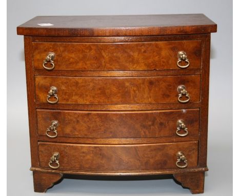 An early 20th century apprentice type miniature burr walnut veneer bow front chest of four graduated long drawers with brass 