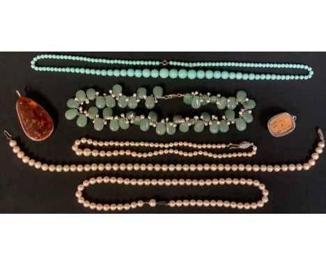 A lady's jade and seed pearl fringe necklace; cultured pearls; an amber pendant; Egyptian scarab pendant; etc 