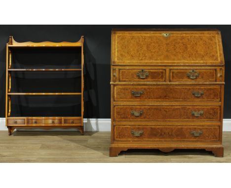 A George III style 'walnut' bureau, 99cm high, 90.5cm wide, 47cm deep; a yew veneered wall hanging shelf rack, by Reprodux, t