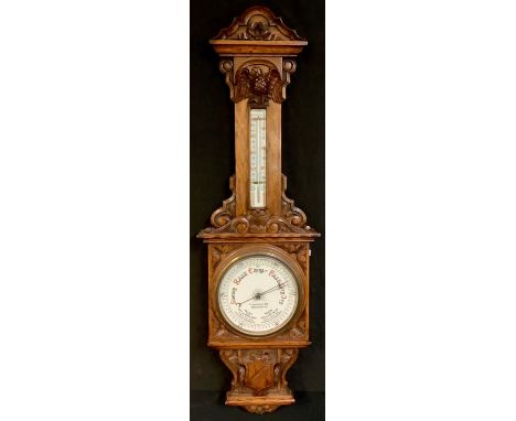 A late Victorian oak barometer, the dial inscribed Finnigans Ltd, Manchester, the case with shaped cornice and eagle, mercury