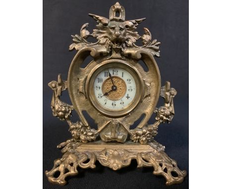 A Victorian brass mantel clock, cast with lion mask and floral swags, 16.5cm high 