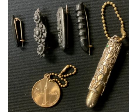 A Whitby jet brooch, three others similar; a lady's brass cigarette lighter; an Empire State Building souvenir token 