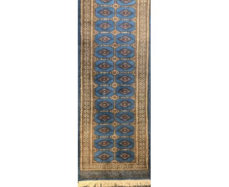 A Persian style hall runner carpet, in shades of brown and red on a blue ground, 74cm wide 