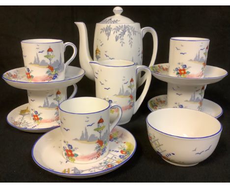 An Art Deco Foley coffee set, printed and enamelled in bright colours with cottage garden and dovecote, comprising coffee pot