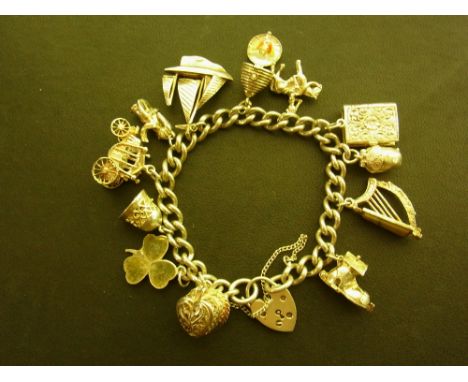 A silver charm bracelet - The curb-link bracelet suspending twelve assorted charms - Padlock hallmarked Birmingham - Length 1