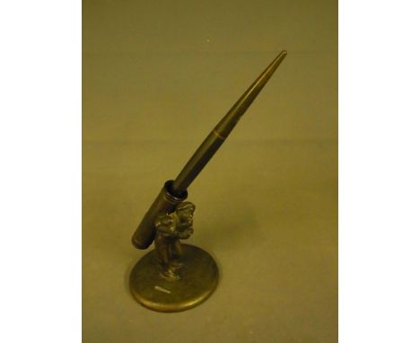 An early 20th century bronzed metal pen stand in the form of a golf caddy together with a 14 k gold pen nib, the base stamped