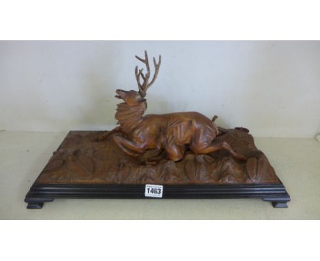 A Black Forest Limewood carving of Stag brought down by a hunting hound on an ebonised base - Height 26 cm x 49 cm x 23 cm 
C