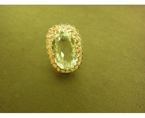 An 18ct gold aquamarine and diamond cluster ring - The oval aquamarine with an old-cut diamond surround to the plain band - E