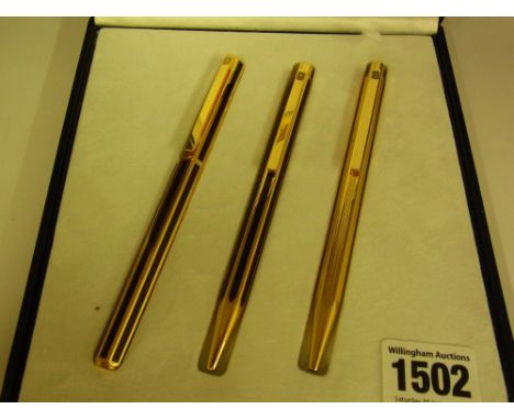 A Caran D'Ache Geneva two piece gold plated pen set with red inlay and a similar ballpoint with engine turned decoration