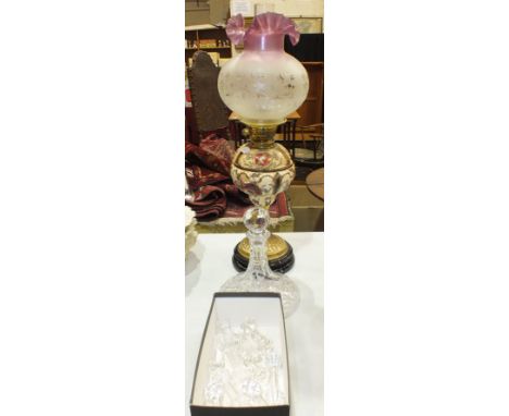 A brass and ceramic oil lamp, the ceramic reservoir with raised floral decoration on brass base and ceramic plinth, with etch