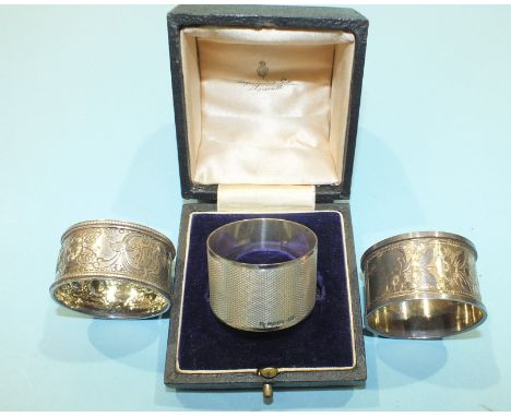 An engine turned silver napkin ring,  Birmingham 1977 and two other silver napkin rings, (3).