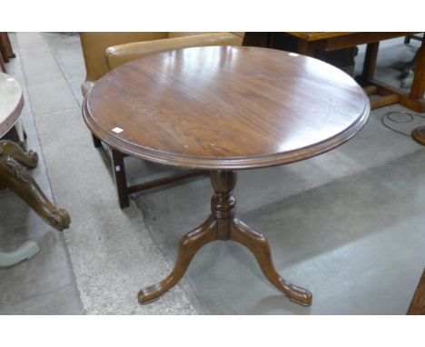 An oak circular tripod table