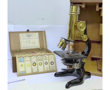 An Ernst Leitz Wetzlar microscope, spare lenses and a box of specimen slides, cased