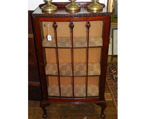 A 1920s bow-fronted mahogany display cabinet, raised on ball and claw feet. H: 133cm W: 70cm D: 33cm