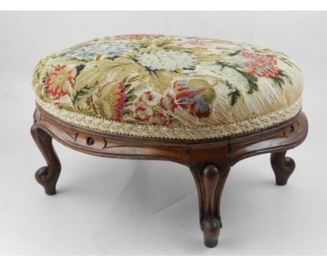 A late 19th / early 20th century French oak footstool, upholstered in a floral tapestry, raised on cabriole legs. H: 17cm W: 
