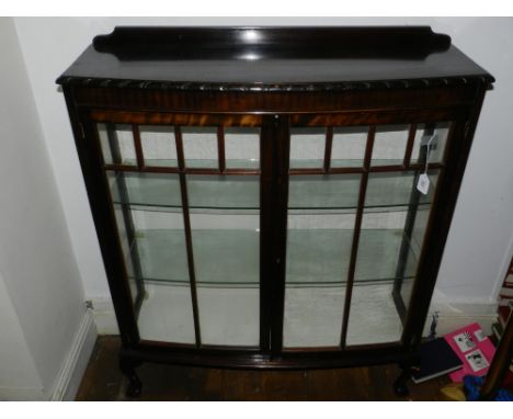 A 1920s bow-fronted mahogany display cabinet, raised on ball and claw feet. H: 126cm W: 103cm D: 30cm