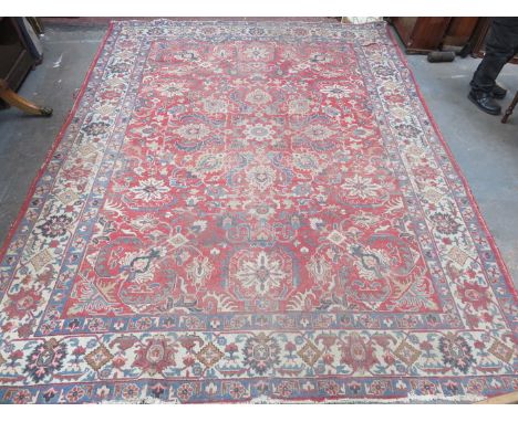 A HEREZ PERSIAN CARPET WOVEN STYLISED FLOWERS ON A RED GROUND, WITH FAWN BORDER 