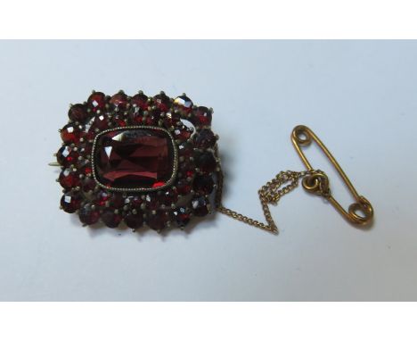 VICTORIAN YELLOW METAL BROOCH SET WITH RUBY COLOURED STONES 