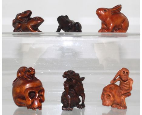 Six boxwood netsuke to include a rabbit, a rat on a skull, a dragon, two toads and a memento mori featuring a skull with a sk