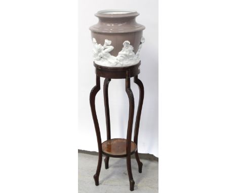 An Edwardian mahogany circular jardinière with lower shelf on tapering cabriole supports, height 93cm and an associated ceram