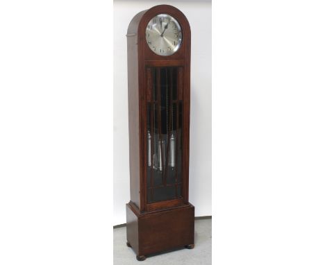 An Art Deco oak arched-top longcase clock with three-train movement chiming, striking and moving the works, the dial set with