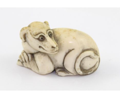 A Meiji period Japanese ivory netsuke in the form of a recumbent dog, character signature marks to the base, height approx 2.