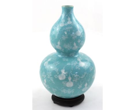 A Chinese porcelain double gourd vase in turquoise crackle glaze with painted decoration in the vine and gourd pattern in whi