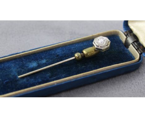 An Art Deco yellow and white metal stick pin with one central diamond.