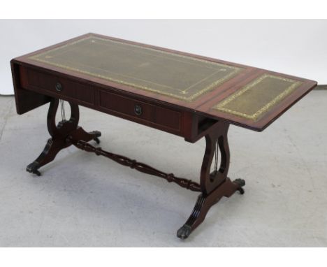 A modern reproduction mahogany sofa table with olive green gilt-heightened tooled leather top, supported on twin lyre-shape s