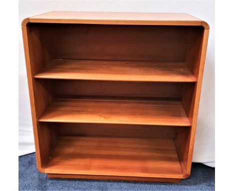 LIGHT TEAK SIDE CABINETthe plain top with rounded corners above an open front with two adjustable shelves, standing on a plin
