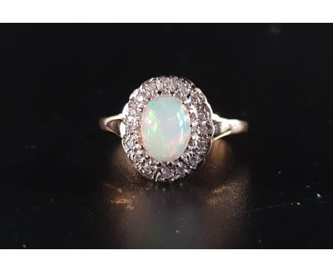 OPAL AND DIAMOND CLUSTER RINGthe central oval cabochon opal in sixteen diamond surround, on nine carat gold shank, ring size 