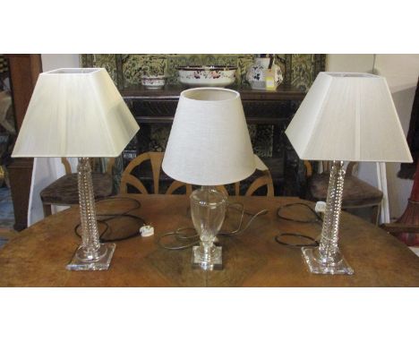 GLASS TABLE LAMPS, a pair, each with a turned column and a beige shade, 65cm H and another glass table lamp with a beige shad