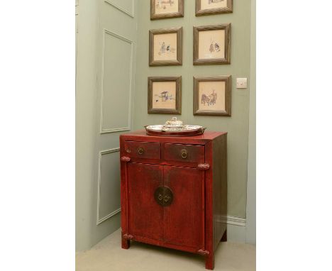 A Chinese red-lacquered low cupboard,late 19th century, the two drawers over a cupboard beneath, each having brass ring handl
