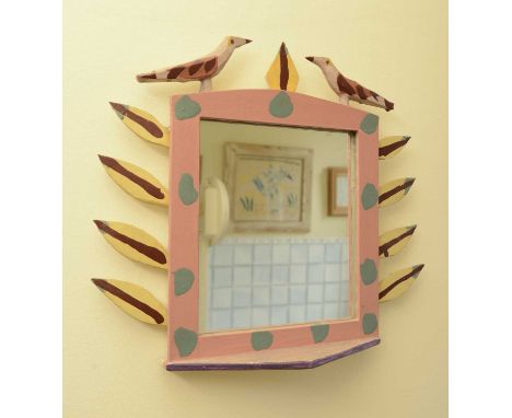*Bryan Illsley (b.1937),a wall mirror surmounted by two birds around a brightly painted frame set with stylised leaves and wi