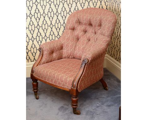 A Victorian mahogany library armchair,the button upholstered back, and reeded and carved arms, raised on turned front legs an