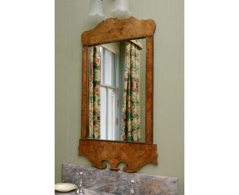 A George II-style walnut fret-framed mirror,the shaped top and bottom around a rectangular plate,60cm wide103cm highCondition