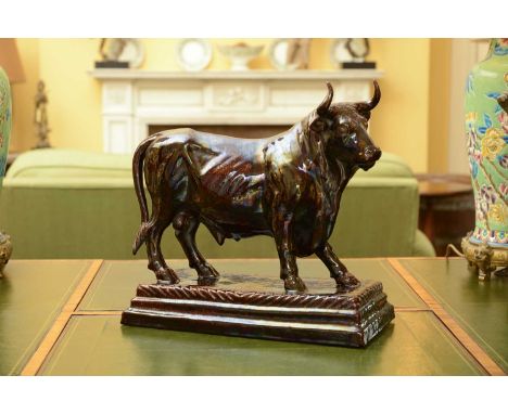 A large brown-glazed pottery model of a bull,on a rectangular base, impressed mark to the underside, 'B. Jafra, Caldao, Portu