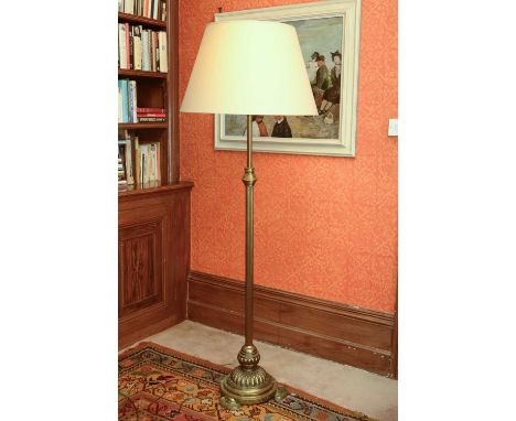 A brass standard lamp,19th century, the adjustable reeded column support on a gadrooned circular base and semicircular feet, 