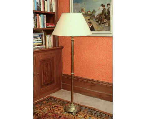 A brass standard lamp,19th century, the column support with a central turned boss and on a paterae decorated circular base an