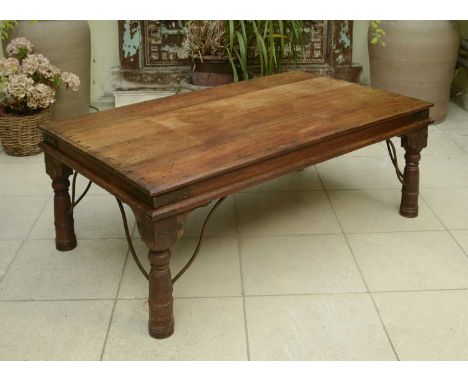 An Indian hardwood low table,20th century, the planked top on iron-bound ring-turned legs,131cm wide80cm deep49cm highConditi