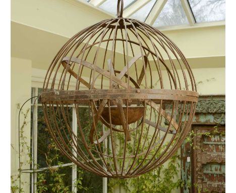 A large wrought iron gimballed light fitting,20th century, Indian, of spherical form and suspended on a heavy chain,80cm diam