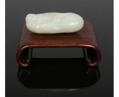 A Chinese pale celadon jade carving of a sage dressed in a robe and flanked by a pair of ruyi sceptres. Raised on an associat