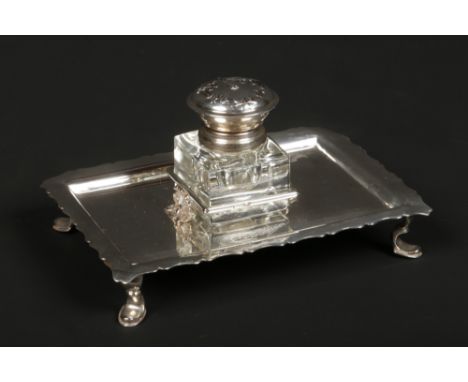 A silver mounted glass inkwell on associated stand. The rectangular stand with scalloped rim is supported on four cabriole fe
