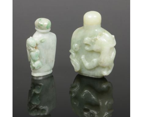 Two Chinese pale jade snuff bottles with stoppers. One carved surmounted by a mythical beast and the other with a squirrel cl